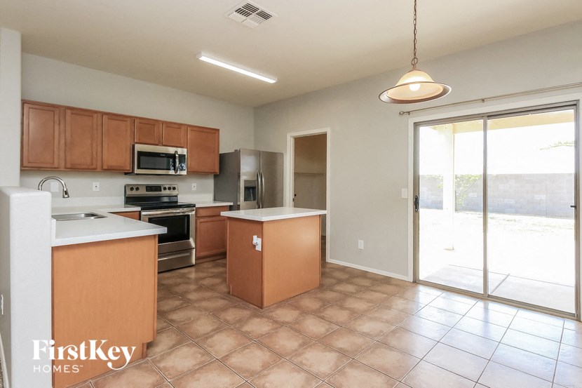 an empty kitchen with a sliding glass door to the patio