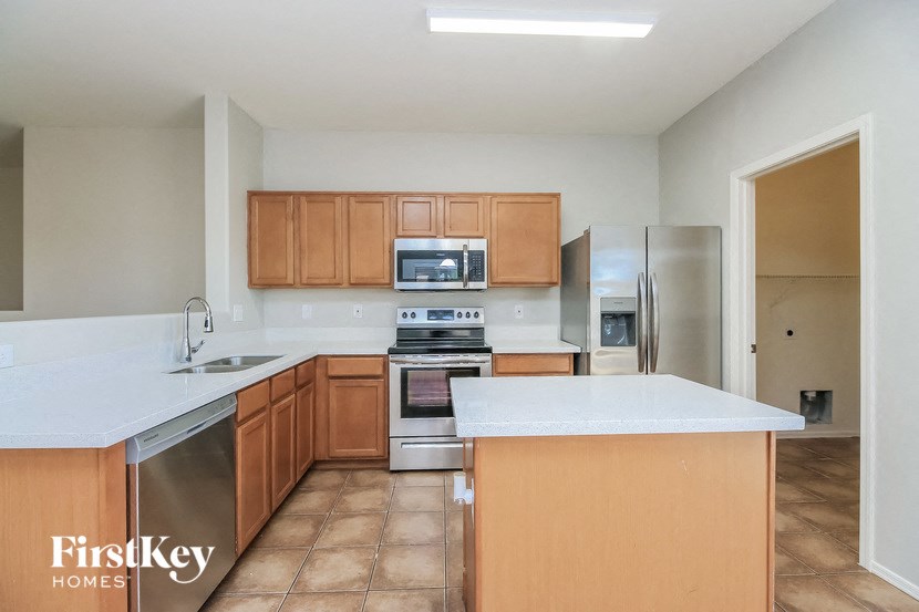 a large kitchen with wooden cabinets and stainless steel appliances