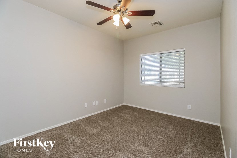 an empty room with a ceiling fan and a window