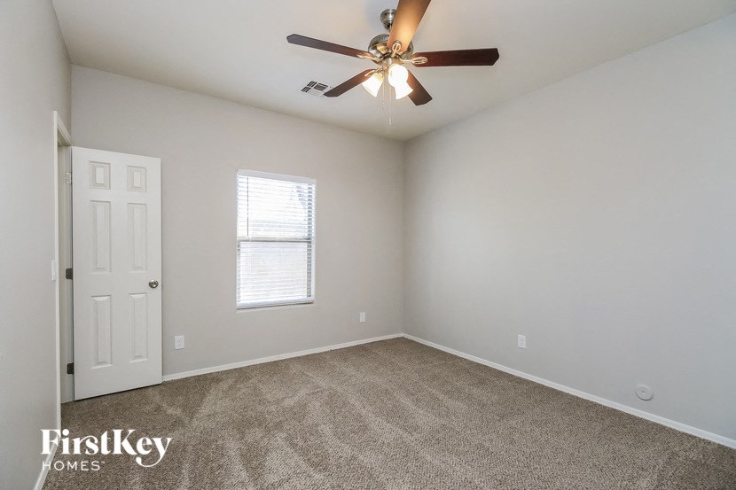 an empty room with a ceiling fan and a door