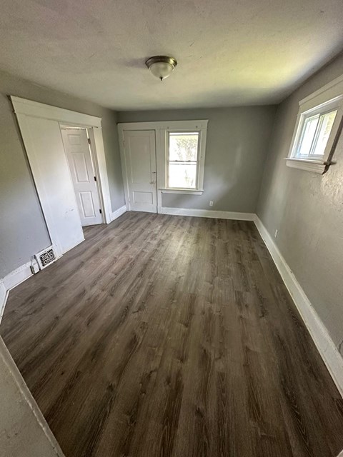 a empty living room with a wooden floor