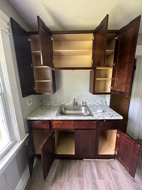 an empty kitchen with a sink and cabinets