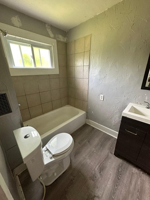 a bathroom with a toilet and a tub and a sink