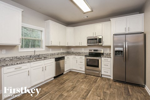 A kitchen with white cabinets and stainless steel appliances.