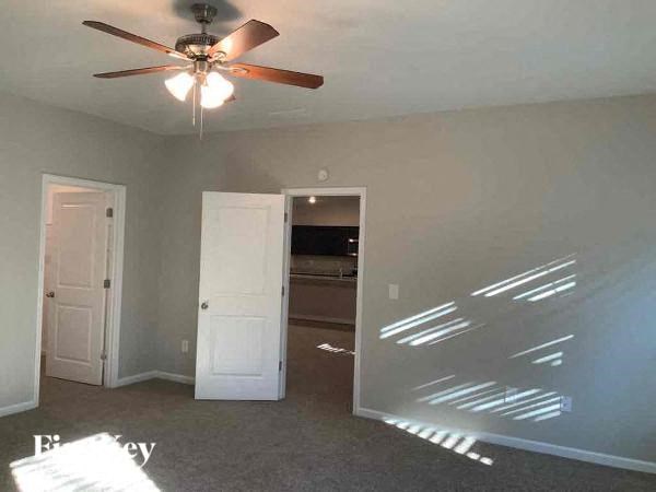 an empty living room with a ceiling fan
