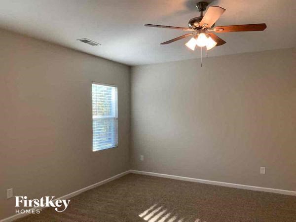 an empty room with a ceiling fan and a window
