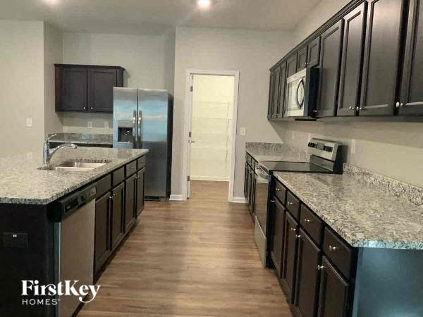 a kitchen with granite counter tops and a stainless steel refrigerator