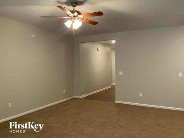 an empty living room with a ceiling fan