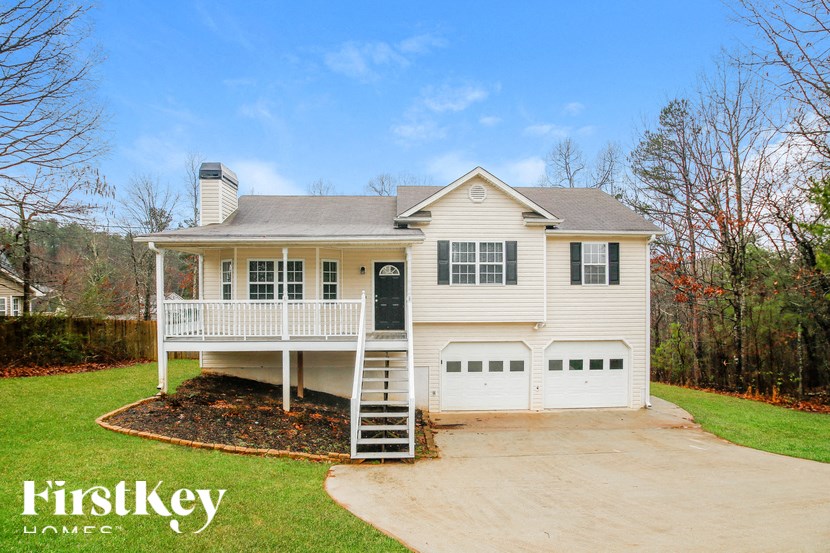 the front of a white house with a garage and a driveway