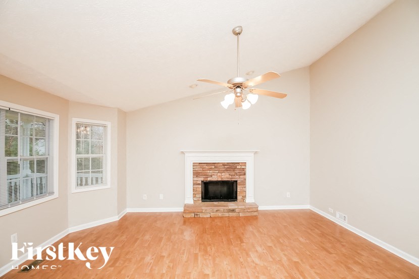 a living room with a fireplace and a ceiling fan