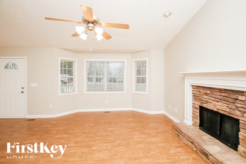a living room with a fireplace and a ceiling fan