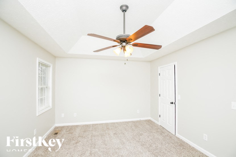 a bedroom with a ceiling fan and a door to a closet