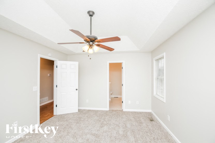 a bedroom with a ceiling fan and a door to a closet