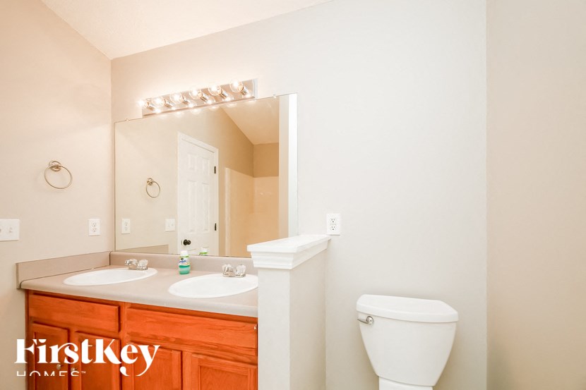 a bathroom with a toilet and a sink and a mirror