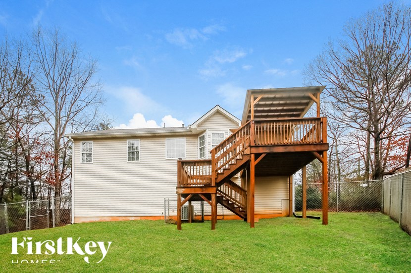 a house with a wooden deck on top of a yard