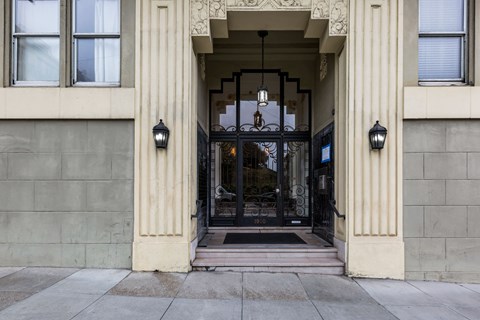 A building entrance with a black gate and a hanging light.