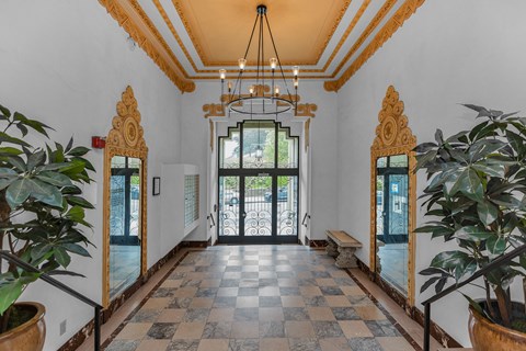 A hallway with a checkered floor and a ceiling light.