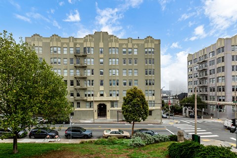A large building with a green lawn in front of it.