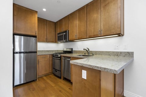 a kitchen with wooden cabinets and stainless steel appliances