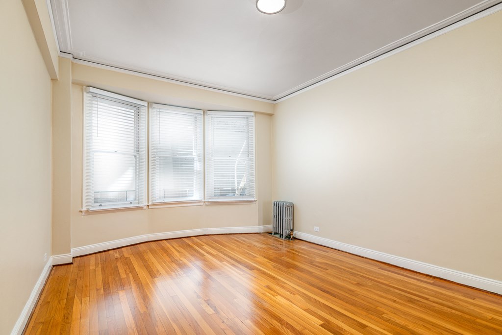 the living room of an empty house with wood floors and windows