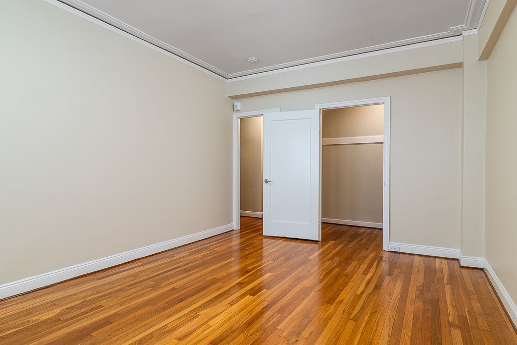 a empty room with wood floors and a closet