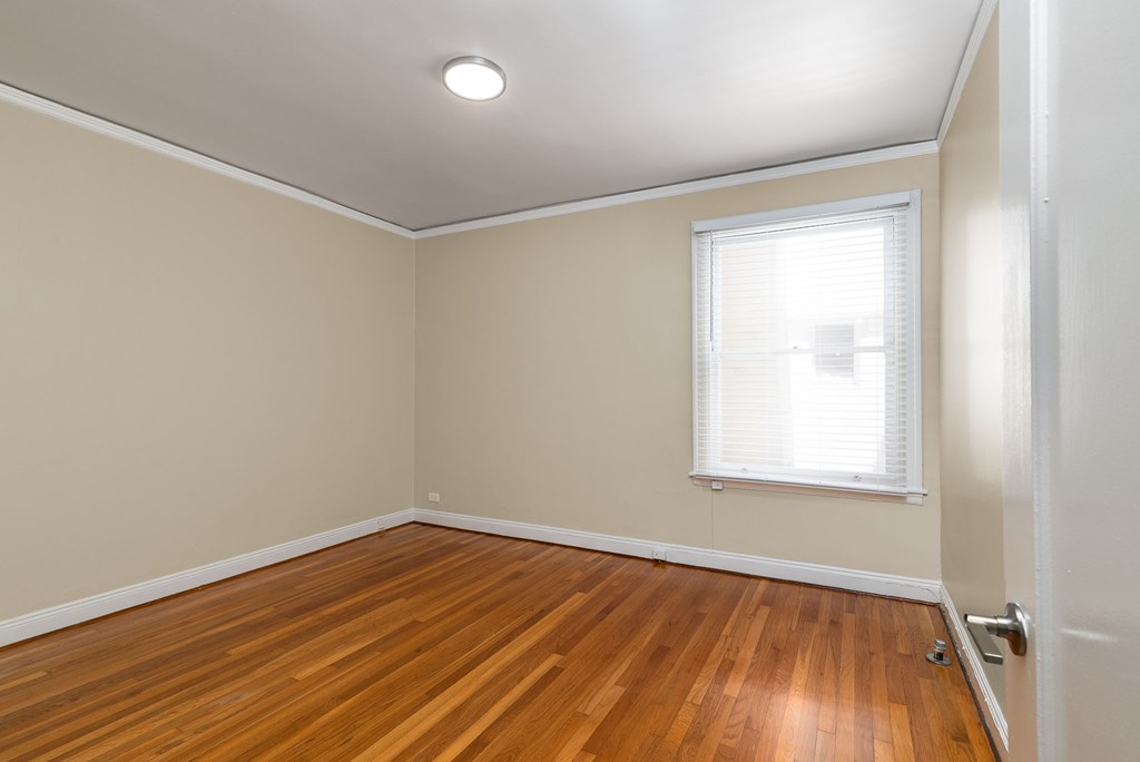 an empty room with wood floors and a window