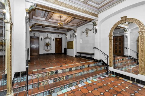 A staircase with a tiled floor and a mirror on the wall.