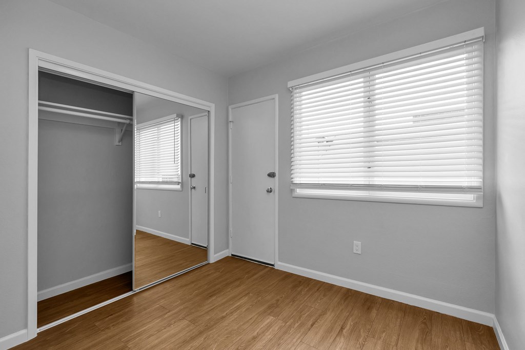 a bedroom with a door to a closet and a window