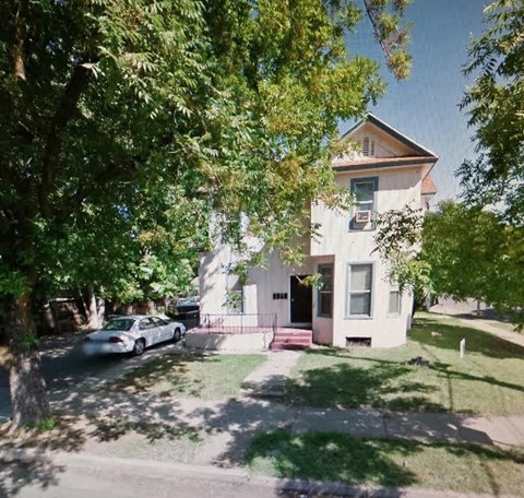 A house with a car parked in front of it.