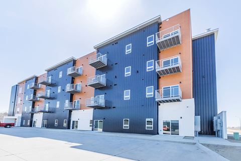 the exterior of an apartment building with blue and orange facade