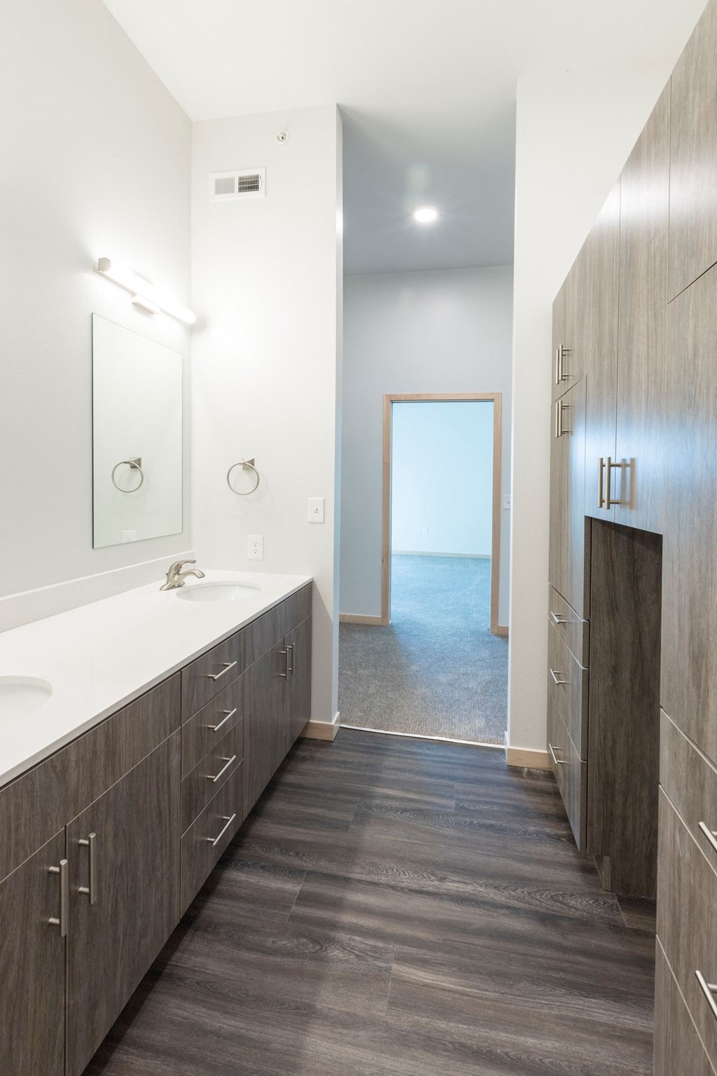 a bathroom with two sinks and a door to the ocean