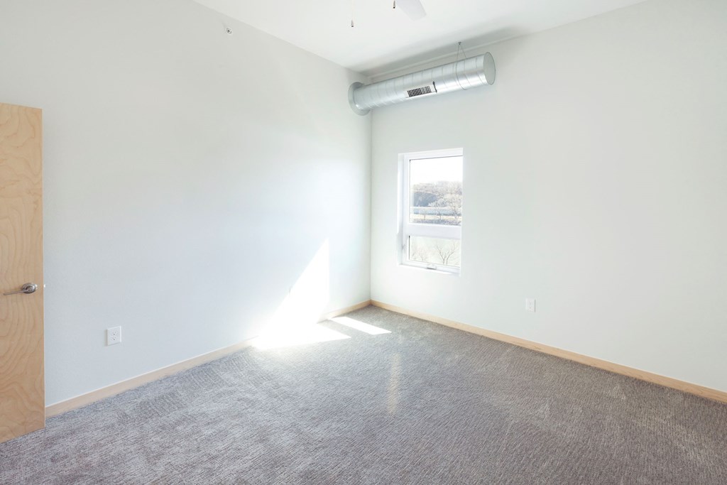 an empty room with white walls and a window