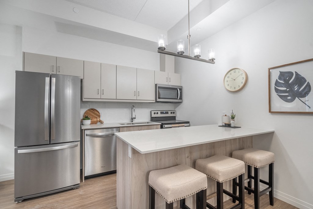 a kitchen with stainless steel appliances and an island with three stools