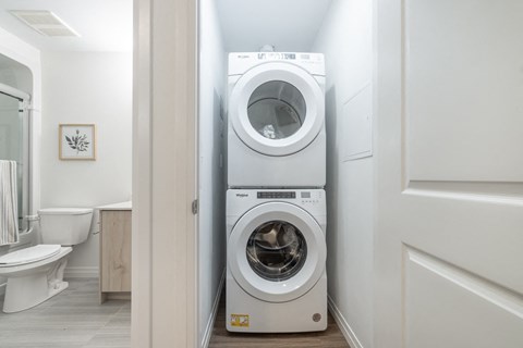 a white washer and dryer in a small laundry room