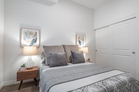 a bedroom with a bed and two lamps and a closet