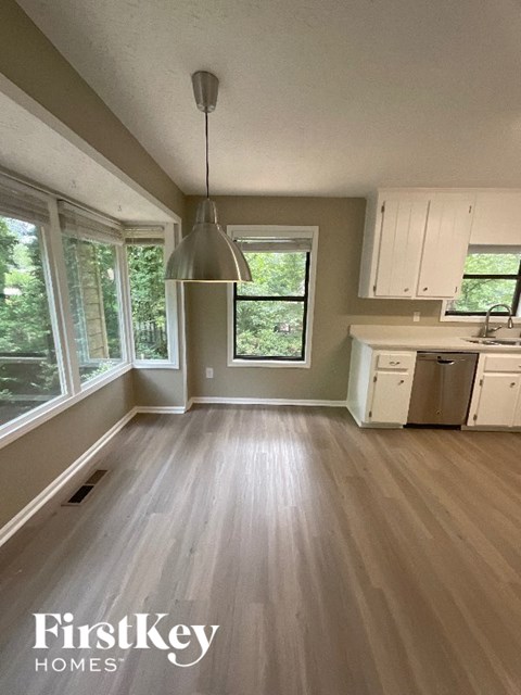 A kitchen with wooden floors and a FirstKey Homes logo.