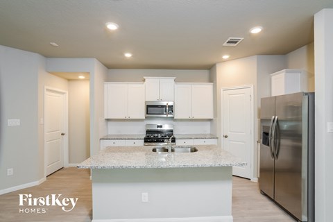 A kitchen with a marble countertop and stainless steel appliances.