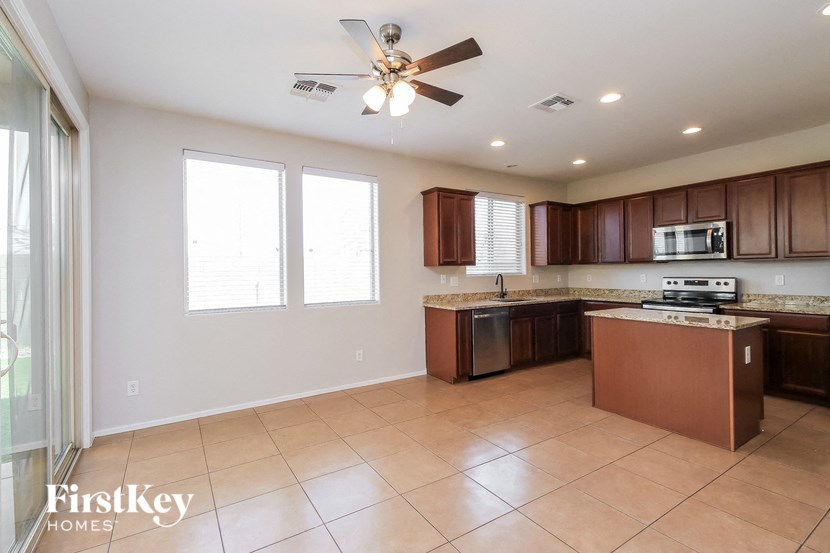 a kitchen with wooden cabinets and a ceiling fan