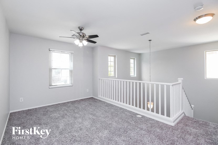 a white nursery with a white crib and a ceiling fan