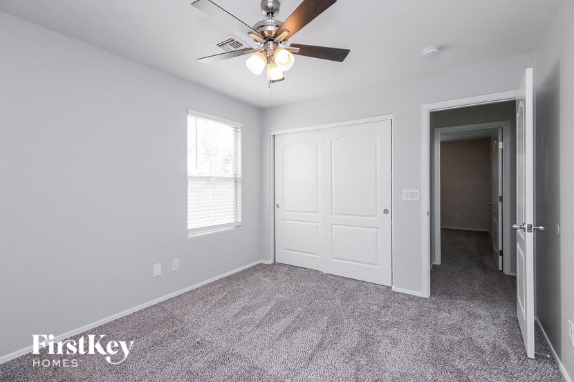 the living room of an empty house with a ceiling fan