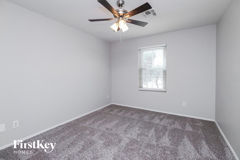 the living room of an empty house with a ceiling fan