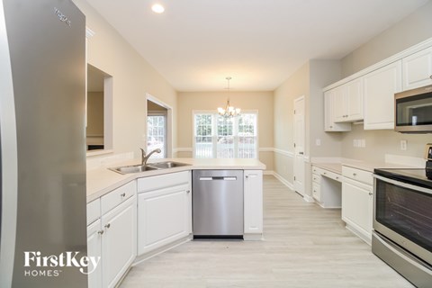A kitchen with white cabinets and a stainless steel refrigerator.
