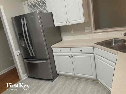 a kitchen with white cabinets and a stainless steel refrigerator