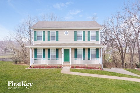A house with a green door and a white porch.
