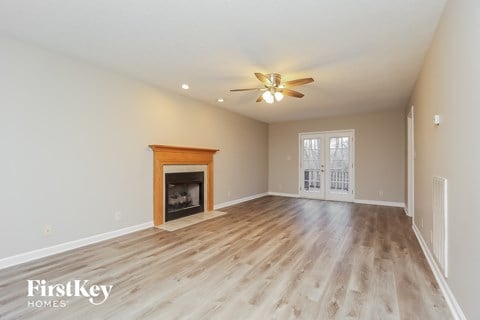 A spacious room with a fireplace and a ceiling fan.