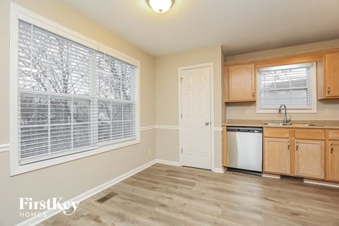 A kitchen with wooden cabinets and a white door.