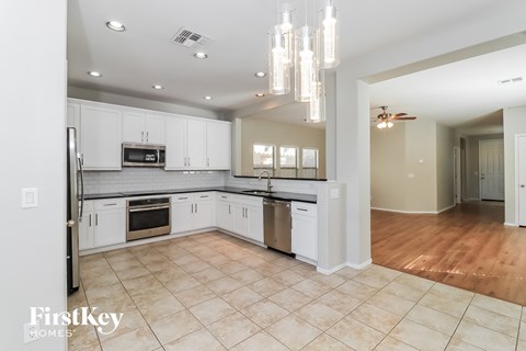 A kitchen with white cabinets and a tile floor.