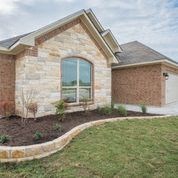 A house with a brown brick exterior and a large window.