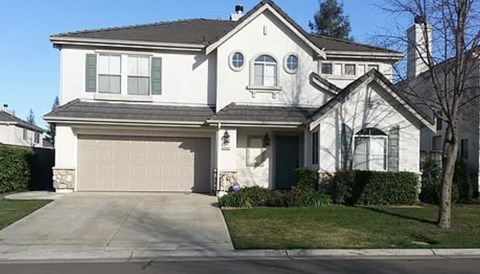 A white house with a grey roof and a grey garage door.