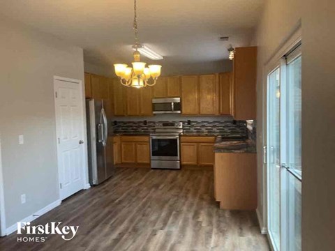 A kitchen with wooden cabinets and a chandelier hanging from the ceiling.